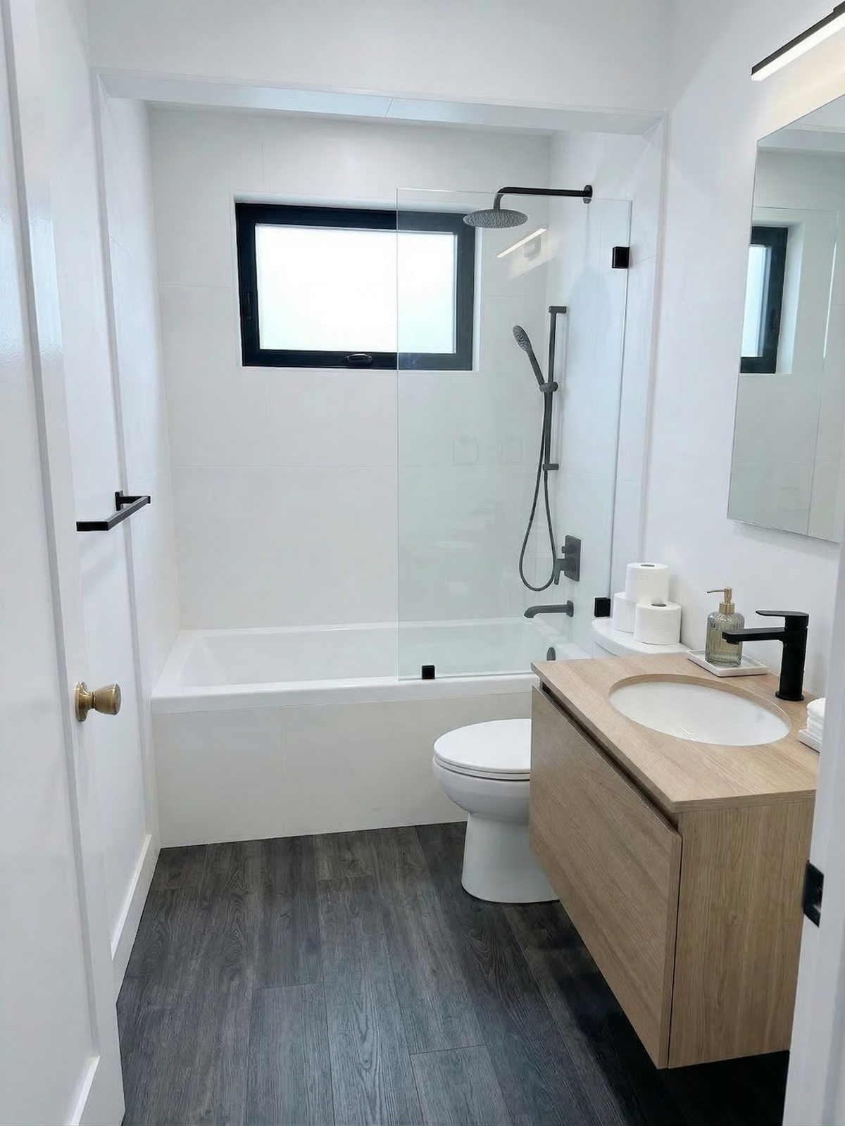 Finished bathroom remodel with tiled tub surround and floating vanity